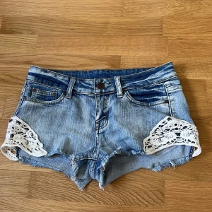 Lågmidjade jeansshorts med spetsdetaljer  - Superfina ljusblåa lågmidjade jeansshorts🥰ingen storlekstabell men passar xs-s, jag är 170 cm 