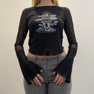 Svart långärmad tröja  - En svart långärmad tröja med tryck, perfekta 90s vibes :) genomskinligt meshtyg på ärmarna och lite utsvängda ärmar. Passar som en S ❤️