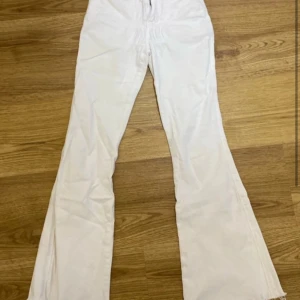 Vita jeansbyxor från Dr. Denim - Snygga vita jeansbyxor från Dr. Denim med en klassisk design. Byxorna har en dragkedja och knappar framtill samt fem fickor. Perfekta för en stilren look. De sitter lågmidjat om du har en lång överkropp, annars sitter de högt eller mid! Priset kan diskuteras! De ligger runt 600-700kr online!