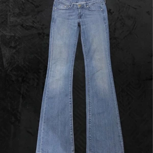 Lågmidjade blåa flare jeans - Snygga blå bootcut jeans med klassisk femficksdesign och knappgylf. Vintage! (Små defekter på knäna)