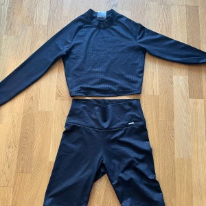 Svart långärmad träningstopp Aim'n - Långarmad topp och cykelshorts från aim’n. Svart med houndstooth mönster. Båda delar i small. Som nya! 