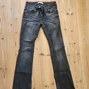 Svarta bootcut jeans från Zara - Snygga svarta jeans från Zara med bootcut passform och klassisk femficksdesign. Jeansen har en lätt tvättad look och är tillverkade i stretchig denim som sitter skönt. Perfekta för dig som gillar en tidlös stil med lite edge.
