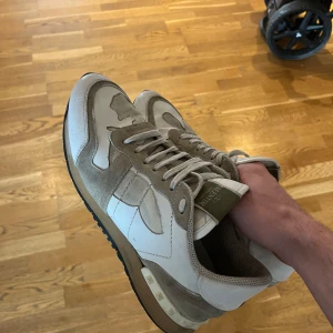 Valentino Rockrunner - Väldigt snygga valentino rockrunner i en vit/beige färg, lite slitna längst fram pö skon men i övrigt bra skick. Storlek 41 men passar upp till 42. Hör av er vid frågor!