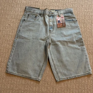 Levi's Skate Short ljusblå jeansshorts - Säljer ett par Levi's Skate Short jeansshorts i ljusblå tvätt. Klassisk femficksmodell med normal passform och midwaist. Shortsens denim är mjuk och har snygga kontrastsömmar. Perfekta för chill och skate, med cool streetstil och Levi's patch bak.