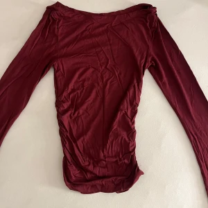 Vinröd långärmad topp Gina Tricot - Säljer en vinröd långärmad topp från Gina Tricot i storlek XXS. Toppen har en enkel och stilren design med rund halsringning och är tillverkad i mjuk bomull. Perfekt att matcha med jeans eller kjol för en snygg look.