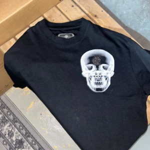 Svart tshirt - Säljer en snygg svart tshirt med design på framsidan. Den är riktig storlek det är storlek S.