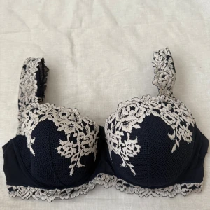 Intimissimi bh mörkblå 75D - En av deras klassiska bh:ar, denna är av modellen balconette och är mörkblå med ljusa blommiga spetsdetaljer. Lappen är avklippt men har en screen med från orderbekräftelsen på hemsidan. Bra skick generellt då den inte hann användas så många gånger innan den blev för stor för mig. Enda defekten är att vänstra bygeln har gått igenom stygnen (se bild). Nypris 499kr.  Pris kan eventuellt diskuteras