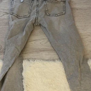 Grå flared jeans från Gina Tricot - Säljer ett par grå flared jeans från Gina Tricot, modellen Perfect Jeans. De har klassiska fem fickor, smal passform och snygga kontrastsömmar. Perfekt för dig som gillar en enkel och stilren look med lite edge.