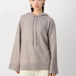 Beige stickad hoodie från Lindex - Mysig beige stickad hoodie från Lindex i storlek XS. Tröjan har huva med snörning, långa ärmar och breda ribbade muddar vid ärmslut och nederkant. Inga defekter förutom att den är lite lite nopprig och en tråd sticker ut (se sista bild) men går säkert attt fixa super enkelt! 💞
