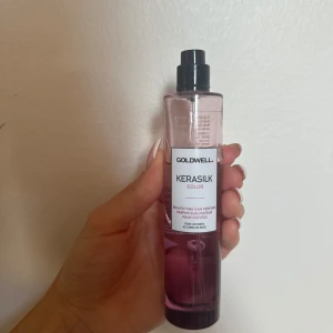 Goldwell Kerasilk Color hårparfym - Goldwell Kerasilk Color hårparfym i en stilren, genomskinlig rosa plastflaska med svart spraymunstycke. Doften har rosackord och är speciellt framtagen för att fräscha upp håret och ge en lyxig känsla.