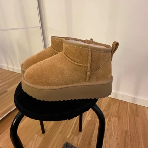 Beiga mockaboots med plattform - Chunky boots i beige mocka med plattformsula och rund tå. Insidan är fodrad med mjukt material för extra värme. Perfekta för kyliga dagar och har en enkel, stilren look som passar till många outfits. Hör av dig vid frågor🌸