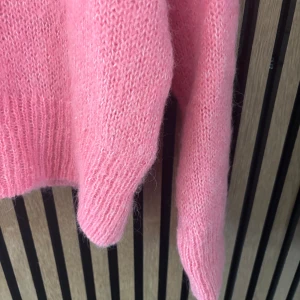 Ljusrosa stickad tröja från H&M - Supermysig ljusrosa stickad tröja från H&M i ull- och alpackablandning. Tröjan har långärmade ärmar, rund hals och ribbade muddar vid ärmslut och nederkant. 
