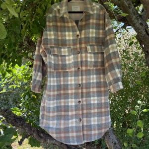 Rutig overshirt från Cream - Säljer en sjukt snygg rutig overshirt från Cream i mjukt material. Jackan har bruna, gråa och vita toner, långa ärmar, två bröstfickor och knappar hela vägen. Perfekt att slänga över en hoodie för en chill look. Storlek L, men är väldigt oversize. Mycket fint skick, jag hittar inga synliga anmärkningar eller defekter. 