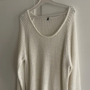 Nättröja - Säljer en vit stickad tröja med grovt nätmönster och rund halsringning. Tröjan har lång ärm och en loose passform, perfekt att slänga på sig över ett linne eller t-shirt. Enkel och stilren design som funkar året runt.