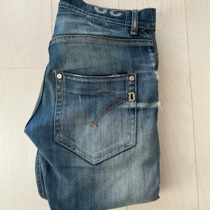 Blåa dondup jeans  - Tja, säljer mina blåa dondup jeans. Modellen är george som slim fit och storleken är 30. Inga defekter förutom lappen inuti. OBS alla slitningar som är på utsidan ska vara så. Skriv vid minsta fundering.