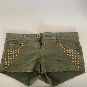Militärfärgade jeansshorts, lågmidja  - Militärgröna shorts med lågmidja och nitdetaljer😇 Har fläck på ena fickan på baksidan men inget man lägger märke till och går säkert bort i tvätten  