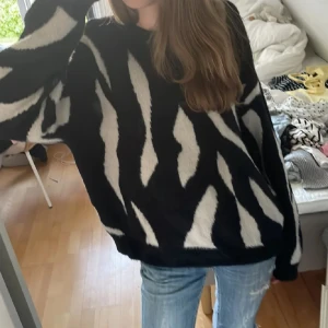 Zebramönstrad stickad tröja från Vila - Säljer en oversized stickad tröja från Vila i svart och vitt zebramönster. Tröjan har lång ärm, rund halsringning och är supermjuk och fluffig. Perfekt för dig som vill sticka ut med en cool och trendig look. Storlek S. Hör av dig om du har frågor eller funderingar💕