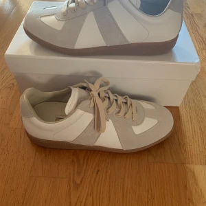 Maison Margiela Gats - Säljer dessa vita margiela gats för bra pris.                         De är storlek 42                                                                            De är som nya, bara provat en gång