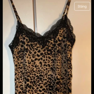 Leopardmönstrad linnetopp från Pieces - Snygg linnetopp från Pieces med leopardmönster i beige och svart. Toppen har tunna axelband och v-ringning med svart spetsdetalj längs kanten. Perfekt för dig som vill sticka ut med ett djurmönstrat plagg.