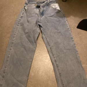 Ljusblå jeans med slits nertill - Säljer ett par ljusblå jeans med raka ben och snygg slits nertill på benen. Klassisk femficksmodell med hög midja och relaxed fit. Perfekta för dig som gillar en chill och trendig look. Materialet är klassisk denim i bomull. Aldrig använt, köpt från shein i storlek S