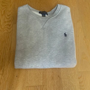 Grå sweatshirt från Polo Ralph Lauren - ✅ I mycket fint skick – knappt använd ✅ Inga fläckar, hål eller noppor ✅ 100 % original, köpt i butik ✅ Nypris: ca 1000 kr  📏 Storlek: L 14-16 år (normal i storleken) 🎨 Färg: Ljusgrå
