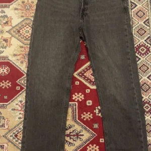 Svarta jeans från Jack & Jones - Säljer ett par svarta jeans från Jack & Jones med klassisk femficksdesign och raka ben. Jeansen har en snygg tvättad look och är tillverkade i slitstarkt denim. Perfekta för dig som gillar en enkel och stilren stil.