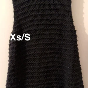 Svart stickad klänning XS/S - Säljer en svart stickad klänning i grovstickat material. Klänningen har en enkel och stilren design som passar perfekt för dig som gillar en avslappnad men ändå trendig look. 🌸 Fint använt skick. Storlek xs/s