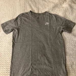 Grå Nike t-shirt i bomull size S - Den är inte använd, om du vill ha mer foton eller har någon fråga skicka till mig så svarar jag Järna. Fotorns säger att den är 170 cm som är S och jag kan konfirmera att det sitter som size S