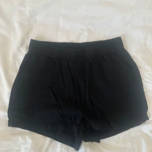 Svarta loose shorts med resårmidja - Svarta shorts med avslappnad passform och bred resår i midjan. Mjukt och lätt material, perfekta för varma dagar. Klassisk och enkel design
