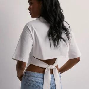 Vit croppad topp med knyt i ryggen - Säljer min öppna rygg tröja från Nelly kommer inte till användning mer