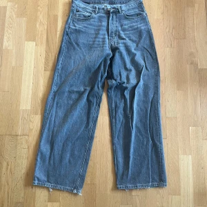 Weekday astro - Säljer ett par grå jeans med rak passform och hög midja. Jeansen har klassisk femficksdesign och rå, fransig kant nertill för en avslappnad vibe. Perfekta för dig som gillar baggy. 30/34