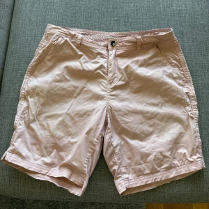 Ljusrosa shorts från Pelle P - •Ett par ljusrosa shorts med fickor fram och bak. •Shortsen har en knappstängning och en lite dragkedja på ena framfickan.  •Det finns en liten logotyp på ena benet. •Perfekta för sommarens alla äventyr. •Aldrig använd, endast tvättad. Köpte för 1500 kr.  •Djurfritt och rökfritt hem