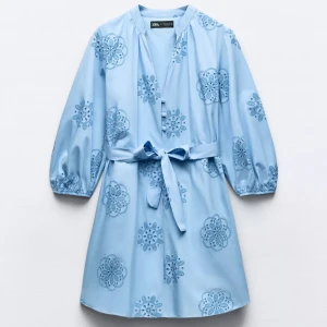 Ljusblå klänning med broderi - Skriv för bilder. Ljusblå klänning med knytband i midjan och trekvartsärmar. Använd fåtal gånger. Lite mindre i storlek.