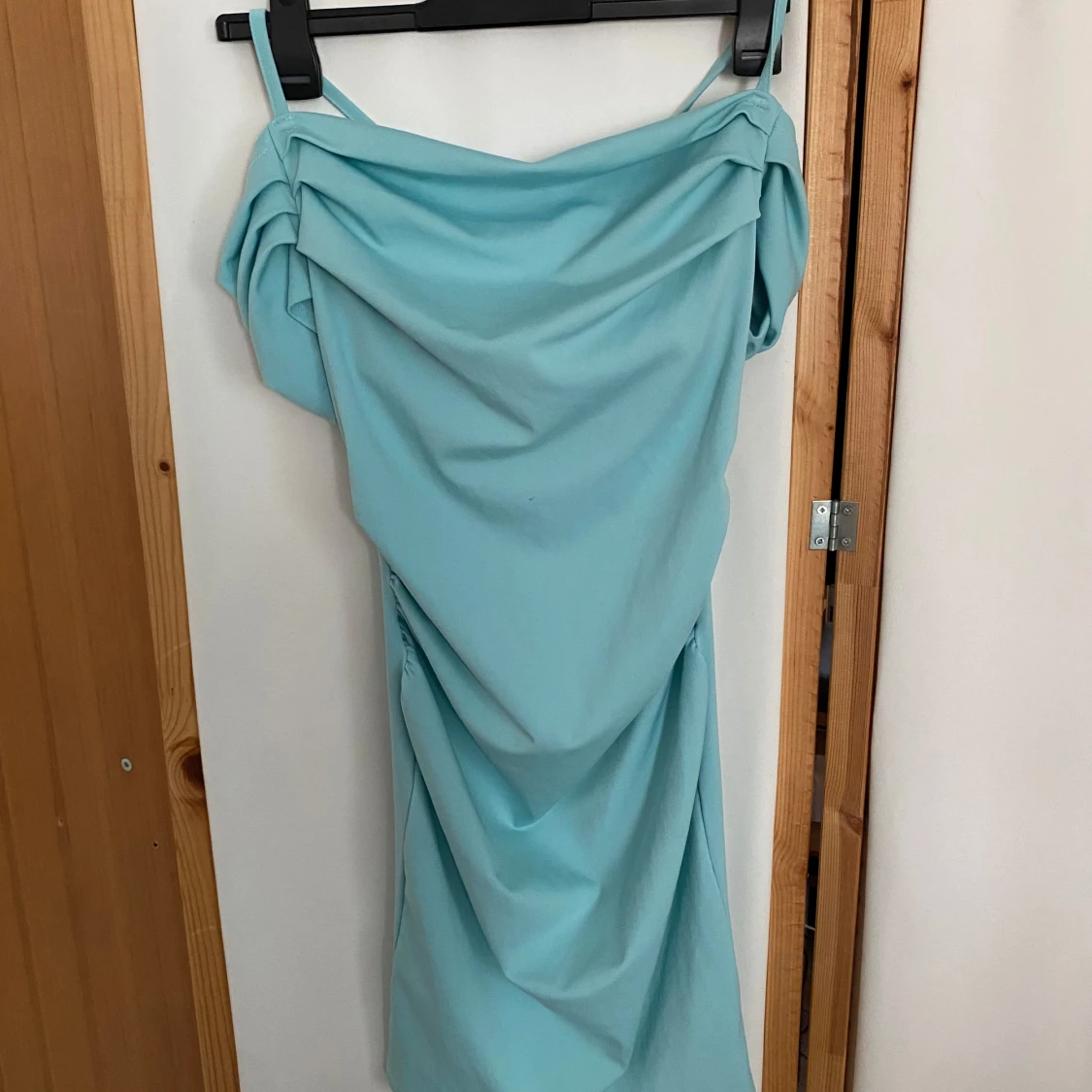 Ljusblå axelbandsklänning med drapering