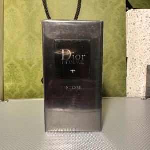 Dior Homme Intense EdP 100ml - Dior Homme Intense Eau de Parfum 100 ml i elegant svart kartong med silverdetaljer. Maskulin och lyxig doft från Dior, perfekt för dig som gillar exklusiva parfymer. Flaskan är av glas och förpackningen är FSC-märkt kartong.