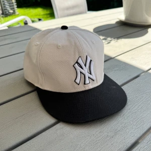 New Era Yankees keps svart/vit - Snygg New Era keps med New York Yankees brodyr framtill och Yankees-text baktill. Sitter jävligt fint och använd 2-3 gånger. Storlek 7 1/8 (56,8 cm). Hör av dig vid funderingar så löser vi en deal🤝