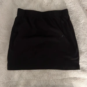 Svart kortkjol från SHEIN - Enkel svart kortkjol från SHEIN i storlek S. Kjolen har resår i midjan