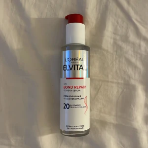 L'Oréal Elvital Bond Repair Serum - L'Oréal Paris Elvital Bond Repair Leave-In Serum med 20% komplex och citronsyra. Kommer i en genomskinlig plastflaska med röd pump och silverdetaljer. Perfekt för att stärka och reda ut skadat hår. Passar alla hårtyper.