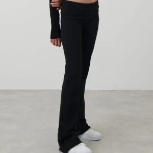 Svarta bootcut byxor i mjukt material - Säljer ett par svarta bootcut byxor med låg midja. De är stretchiga och sitter tajt upptill men släpper ut vid benen. Perfekta till sneakers och crop top för en chill och trendig look.