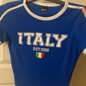 Blå Italy t-shirt från Gina Tricot - Blå t-shirt med vita detaljer från Gina Tricot. Jätte bra skick aldrig andvändts typ 