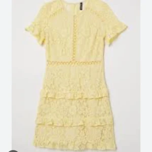 Gul spetsklänning med volang - Söt gul kortklänning i spets med volangdetaljer och korta ärmar. Klänningen har rund halsringning och fina spetsmönster över hela plagget. Perfekt för sommarens alla tillfällen och ger en fräsch och ljus look.