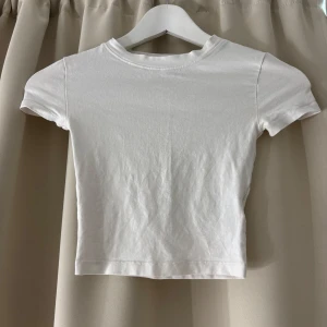 Vit croppad t-shirt - Enkel och stilren vit croppad topp med korta ärmar och rund hals. Sitter skönt på! Om fler bilder önskas eller vid frågor kontakta mig💋