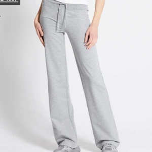 Grå mjukisbyxor med snörning - Snygga ljusgrå mjukisbyxor med breda ben och snörning i midjan. Byxorna har en relaxed fit och är tillverkade i mjukt bomullsmaterial, perfekta för chill dagar eller när du vill vara extra bekväm.