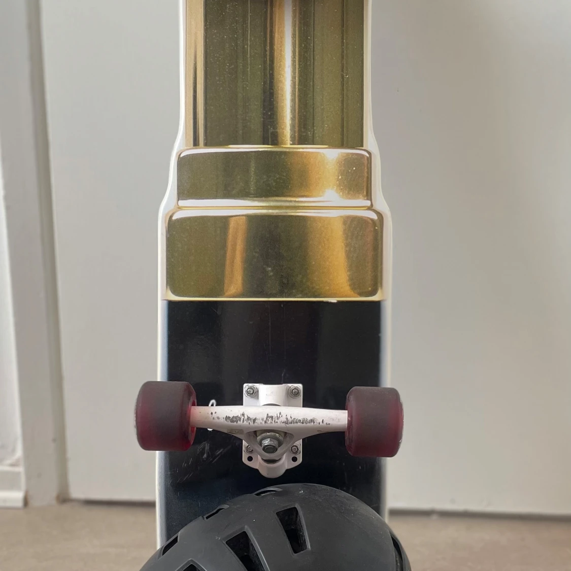 Svart skateboardhjälm med ventiler samt en skateboard  - 1