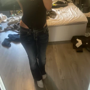 Mörkblå bootcut jeans från Miss Me - Säljer ett par mörkblå Miss Me jeans med bootcut och låg midja. Jeansen har snygga kontrastsömmar och bakfickor med bling och broderade detaljer. Klassisk femficksmodell i stretchig denim som sitter riktigt snyggt på kroppen. Säljer pga att de är för lite för korta på mig