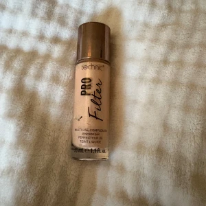 Technic Pro Filter Foundation Fair - ANVÄND‼️Technic Pro Filter är en multi-use complexion enhancer i nyansen Fair. Flytande foundation i glasflaska med guldig kork, perfekt för en naturlig och jämn bas. Vegansk formula och enkel att applicera för en flawless look.