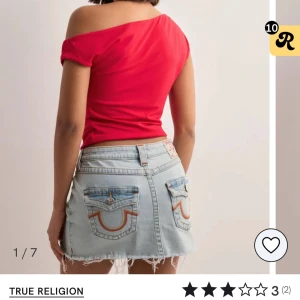 Ljusblå jeanskjol från True Religion - Snygg ljusblå jeanskjol från True Religion med råa kanter och stora bakfickor med broderade detaljer. Klassisk femficksmodell och bälteshällor. Perfekt för en cool och avslappnad stil. Säljer då jag köpte i fel storlek. Använd en gång men för kort för dig som har storlek 25 
