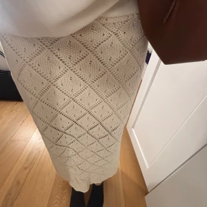 Beige stickad långkjol med mönster - Superfin beige långkjol i stickat material med snyggt hålmönster i rutigt och diamantformat. Kjolen har en rak passform och känns både trendig och bekväm. Perfekt för sommaren. Priset går att diskutera ❤️