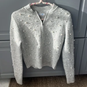 Grå kofta med pärlor från Primark - Superfin ljusgrå kofta från Primark med dragkedja framtill och massor av pärlor över hela tröjan. Stickad och mysig med ribbade muddar vid ärmslut och nederkant. Perfekt för dig som gillar detaljer och vill sticka ut lite extra. Kom privat för bild på😍