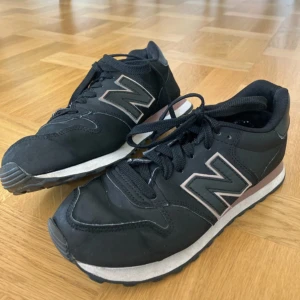 Svarta New Balance sneakers strl 37 - Svarta New Balance sneakers modell GW500BR med klassisk N-logga i grått och vitt på sidorna. Skorna har snörning, platt sula och detaljer i syntet och textil. Lite veckiga framtill men annars i fint skick. Skickas, eller hämtas i Linköping.  Kolla gärna in mina andra annonser!  Allt gott, K